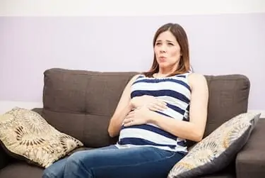 Young pregnant woman focusing on her breathing while she has braxton hicks contractions