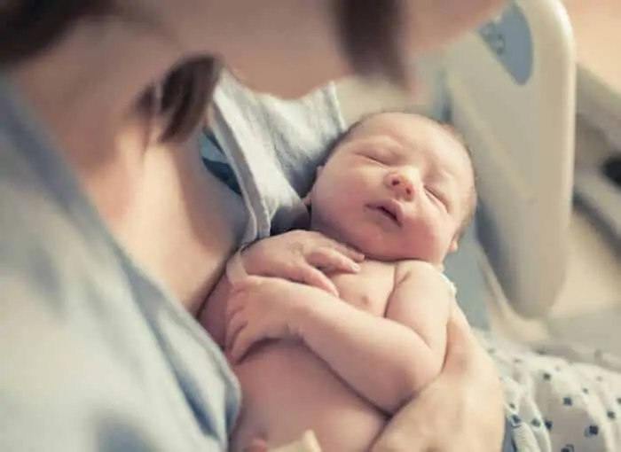 New born baby boy resting in mothers arms