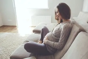 Home cozy portrait of thin pregnant woman resting at home on sofa