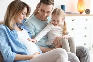 Young pregnant woman with her family at home