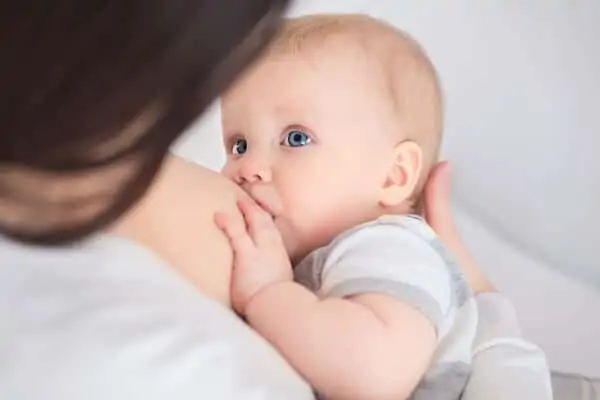 baby looking at mom while breastfeeding
