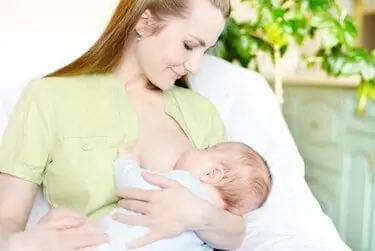 Mom eye-contacts with her baby while breastfeeding