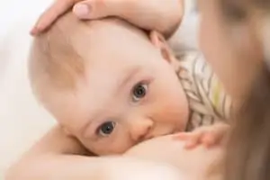 Baby newborn feeds on mother's breasts milk