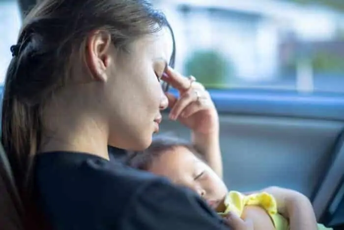 Tired stressed out mother holding her baby