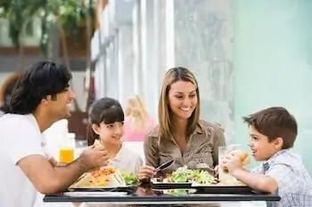 Family at restaurant eating and smiling