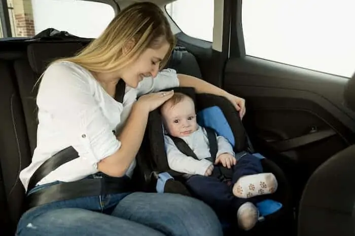 Mother with baby boy on car back seat