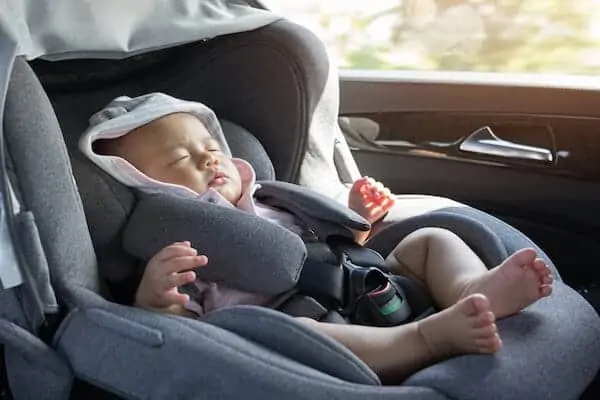 cute newborn sleeping in modern car seat