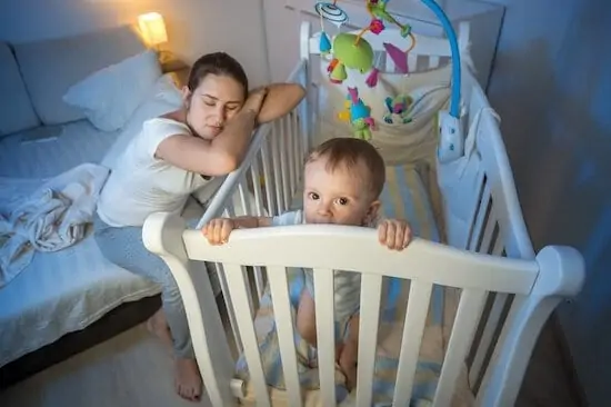 tired mother got asleep next to baby