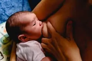 a newborn baby getting breastmilk