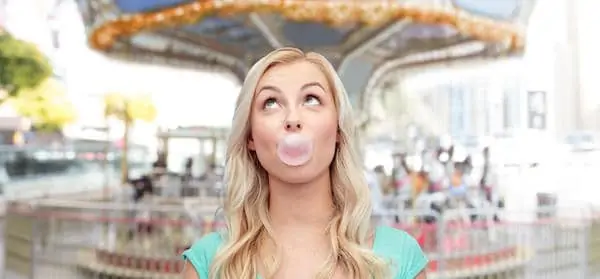 Teenage girl chewing gum over carousel