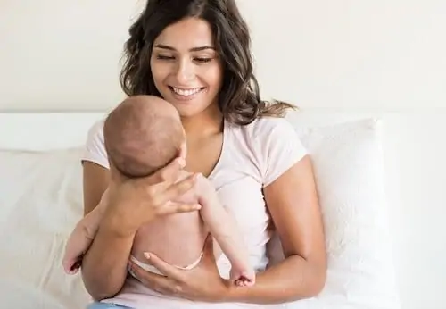 Lovely mother holding newborn baby in arms