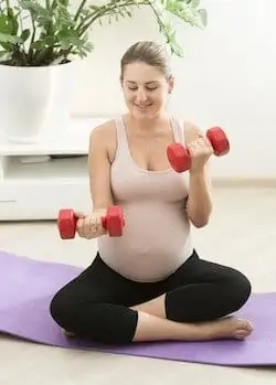 pregnant woman doing dumbbells 