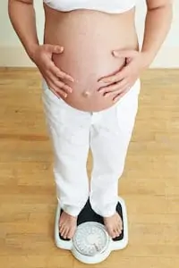 pregnant woman weighing herself