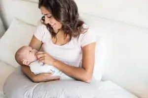 Mother playing with baby on a pillow