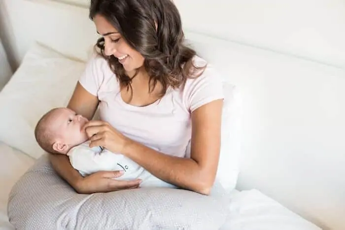 Mother playing with baby on a pillow