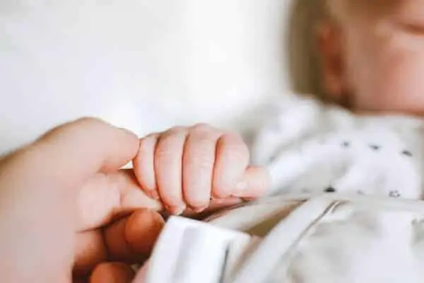 Person holding baby hand