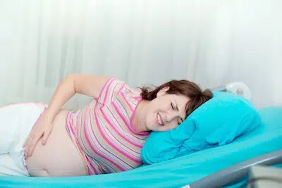 woman on hospital bed feeling pain