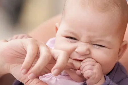 baby bites mom's finger