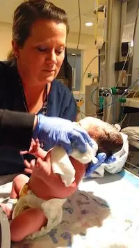 Nurse taking measurement of newborn