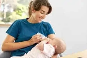 Baby daughter with milk formula from bottle