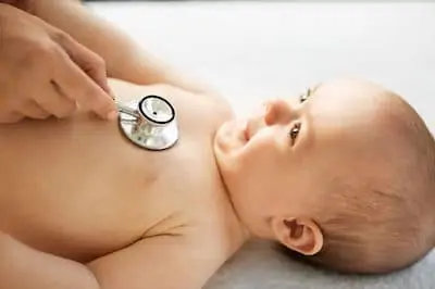 female doctor with stethoscope listening to baby girl’s patient heartbeat
