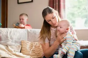 Mother burping her newborn child after feeding him