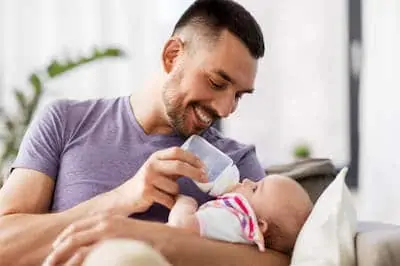 Father feeding little daughter