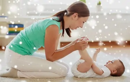 Happy mother playing with little baby