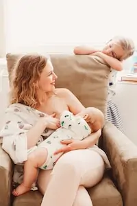 mom holds her breast for feeding