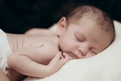 Newborn sleeps on frog position