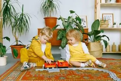 brother and sister playing with toy train