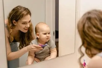 mom trying to brush son's teeth