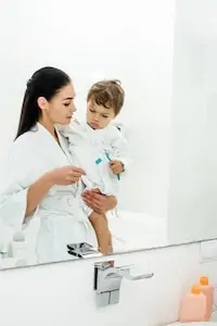 mom helping toddler brushing teeth