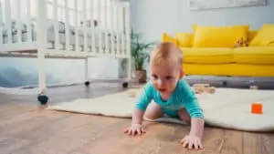 Infant boy crawling on floor