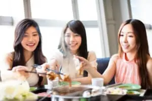 Young women group eating in a hot pot