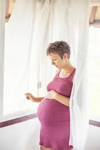 pregnant woman looking at her belly