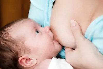 mom tries deep latch holding breast as sandwich