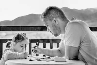 father helping daughter in writing