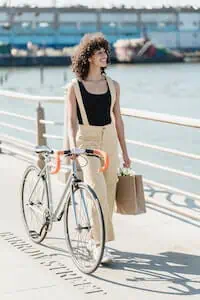 lady holds a cycle and shopping bag