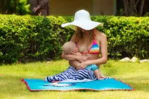 mom breastfeeds child outside