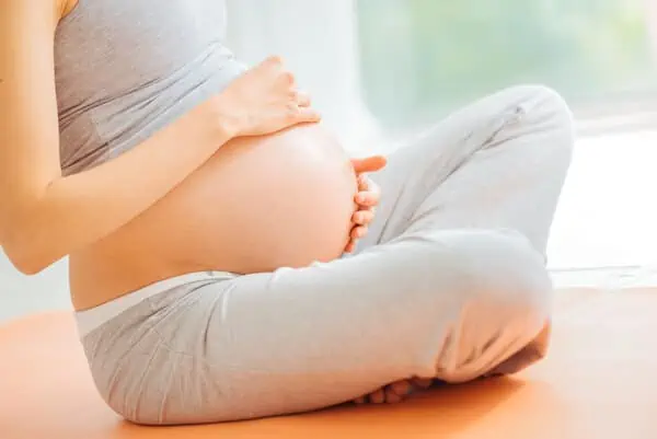pregnant woman sits down on floor