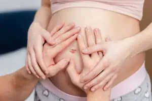 husband touches wife's belly