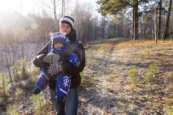 Baby sits in sling in upright position
