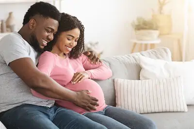 Husband rubs wife's baby bump