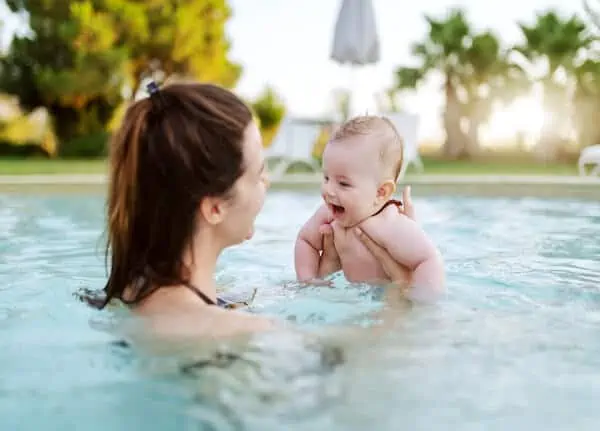 little kid swims with mother