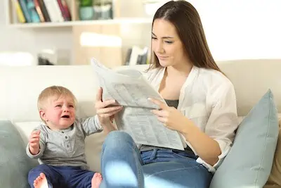 Baby demanding attention and mother ignoring