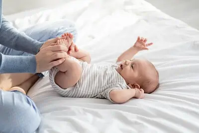 baby exercising by mom