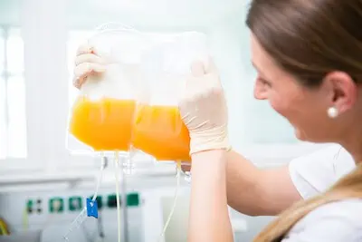 nurse holding plasma collection bag 