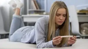 woman confused with a pregnancy test strip