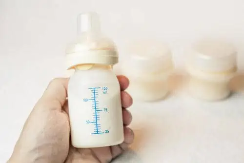 Father trying to hold breastmilk bottle